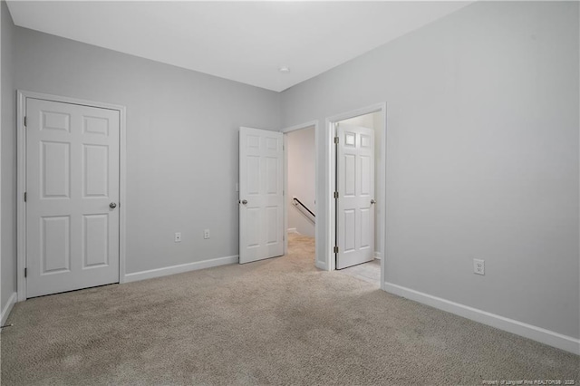 unfurnished bedroom featuring light colored carpet and baseboards