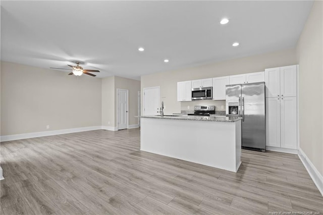 kitchen featuring appliances with stainless steel finishes, a sink, recessed lighting, light wood-style flooring, and white cabinetry