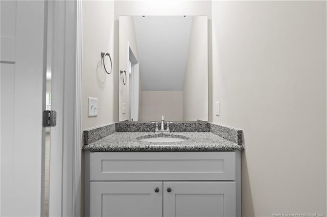 bathroom with vanity and vaulted ceiling