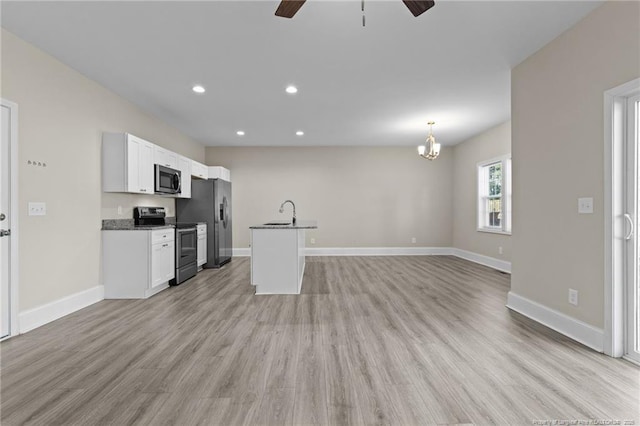kitchen featuring appliances with stainless steel finishes, ceiling fan, dark countertops, light wood finished floors, and recessed lighting