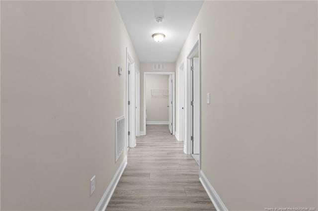 hall featuring baseboards and light wood-style floors
