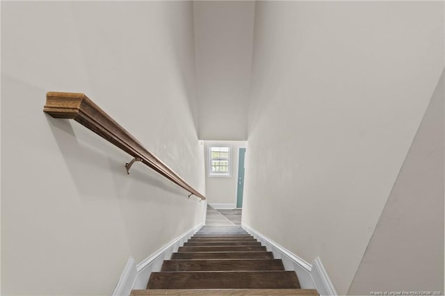 stairs featuring wood finished floors and baseboards