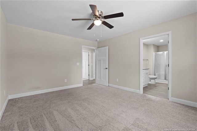 unfurnished bedroom featuring carpet flooring, baseboards, ensuite bathroom, and ceiling fan