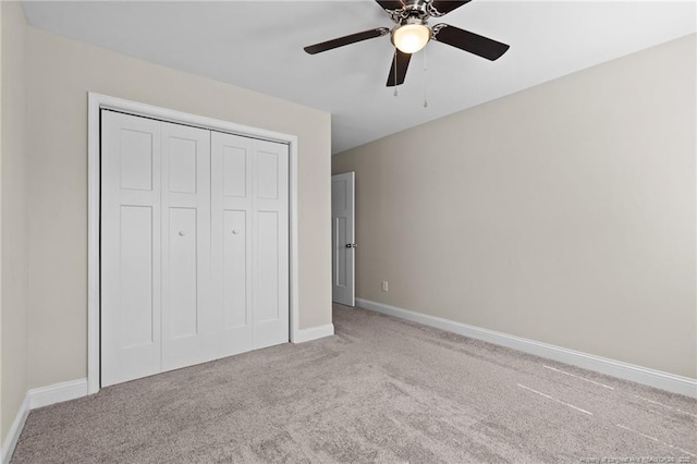 unfurnished bedroom with carpet, baseboards, a closet, and ceiling fan