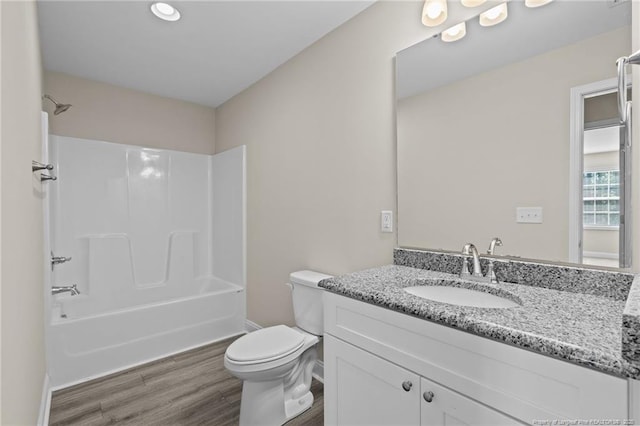 full bath with wood finished floors, baseboards, toilet, and vanity