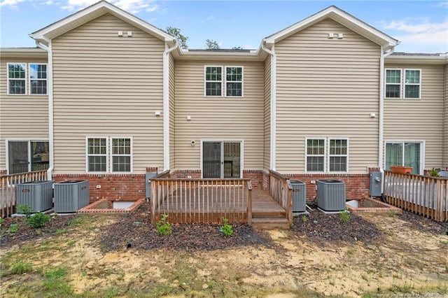 back of house with brick siding, central AC unit, and a wooden deck