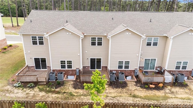 back of property featuring a wooden deck, brick siding, and cooling unit