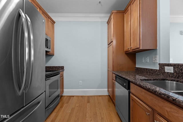 735 Portstewart Dr, Cary, NC 27519 - kitchen with appliances with stainless steel finishes, crown molding, brown cabinets, light wood-style flooring, and baseboards