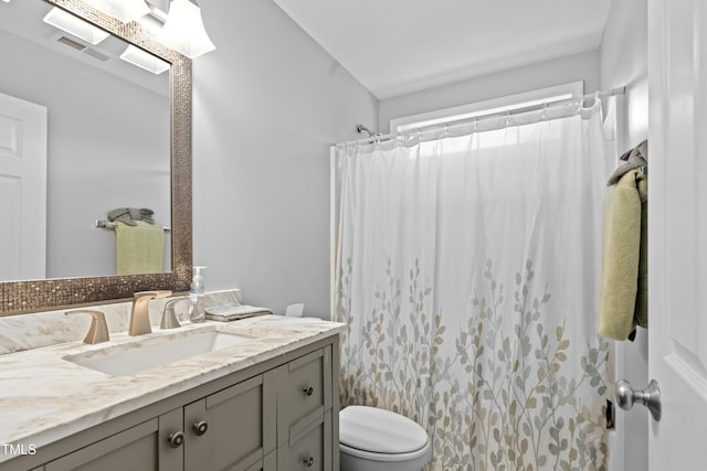 full bath with toilet, vanity, and curtained shower