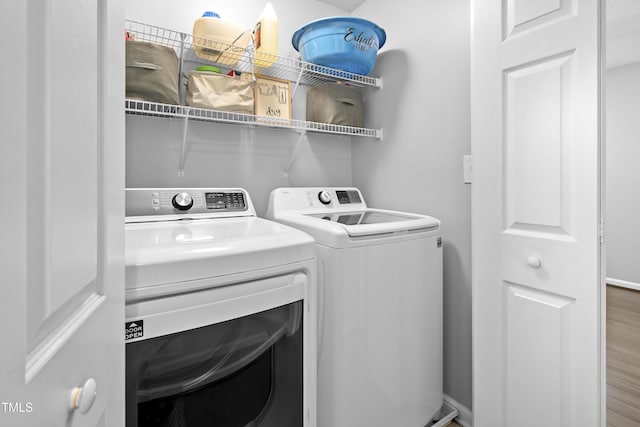 washroom featuring independent washer and dryer, wood finished floors, and baseboards