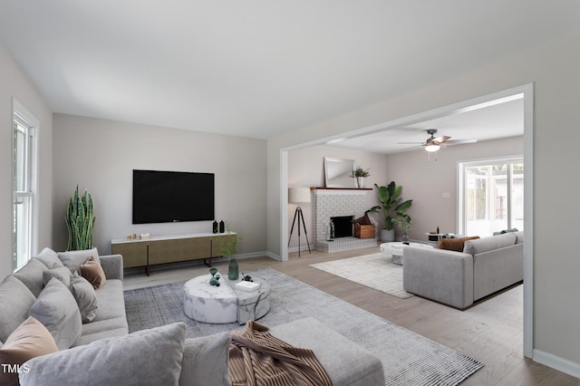 3700 Summer Pl, Raleigh, NC 27604 - living room featuring light wood-style floors, ceiling fan, baseboards, and a brick fireplace