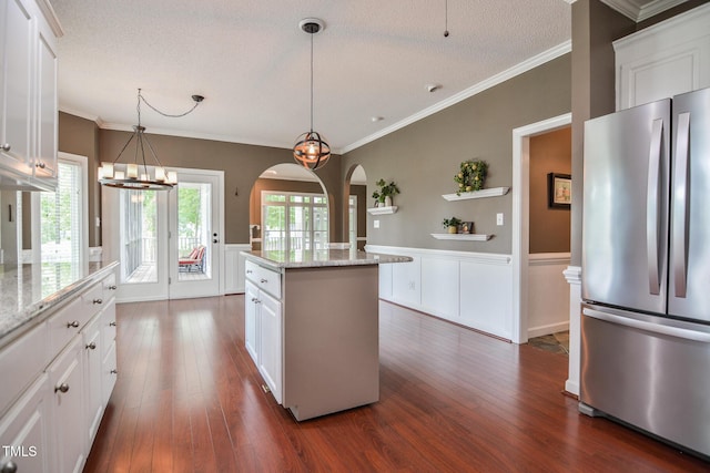 204 Muirfield Ln, Clayton, NC 27527 - kitchen with freestanding refrigerator, a wainscoted wall, arched walkways, dark wood-style floors, and a textured ceiling
