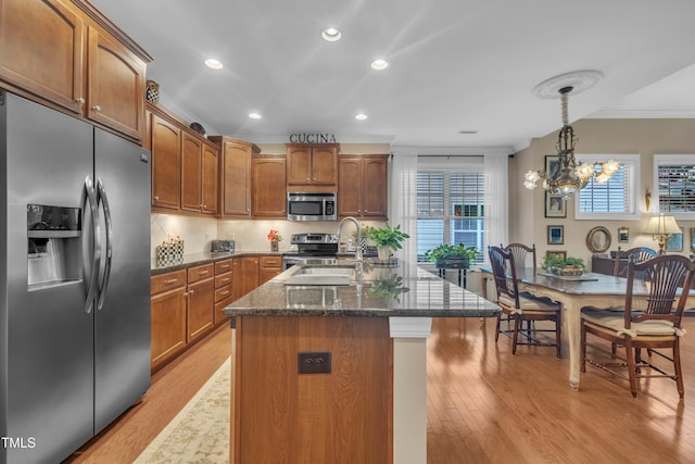 79 Heatherwood Dr, Chapel Hill, NC 27516 - kitchen with appliances with stainless steel finishes, crown molding, a sink, light wood finished floors, and dark stone countertops