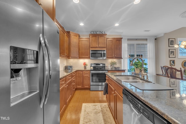 79 Heatherwood Dr, Chapel Hill, NC 27516 - kitchen featuring appliances with stainless steel finishes, a sink, light wood finished floors, dark stone countertops, and recessed lighting