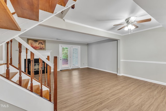 134 Riverwalk Cir, Cary, NC 27511 - unfurnished living room featuring wood finished floors, a ceiling fan, stairs, ornamental molding, and baseboards