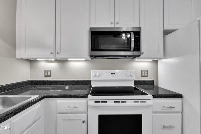 134 Riverwalk Cir, Cary, NC 27511 - kitchen featuring white appliances, white cabinetry, dark countertops, and a sink