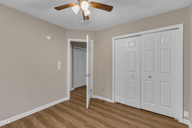 134 Riverwalk Cir, Cary, NC 27511 - unfurnished bedroom featuring light wood finished floors, baseboards, a closet, a textured ceiling, and ceiling fan