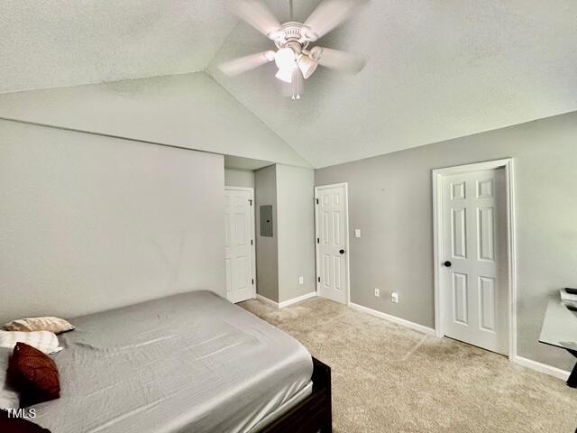 bedroom featuring vaulted ceiling, carpet floors, baseboards, electric panel, and a ceiling fan