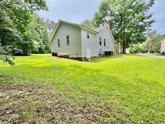 view of side of property with crawl space, a lawn, and cooling unit