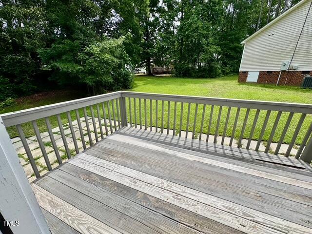 wooden deck with a yard and view of scattered trees