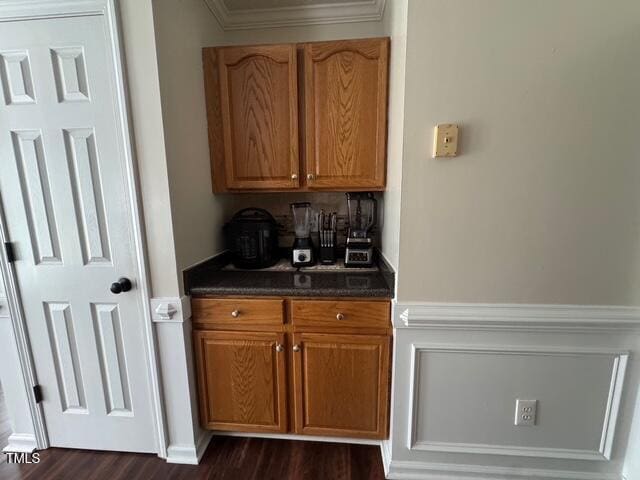 bar featuring dark wood-style flooring and crown molding
