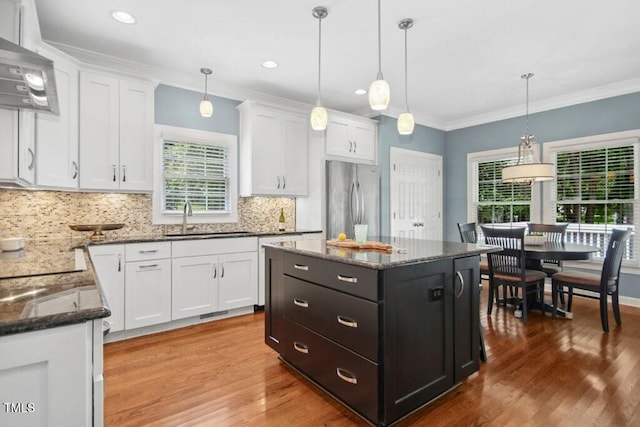100 Wentbridge Rd, Cary, NC 27519 - kitchen with stainless steel refrigerator, a sink, plenty of natural light, white cabinetry, and ornamental molding