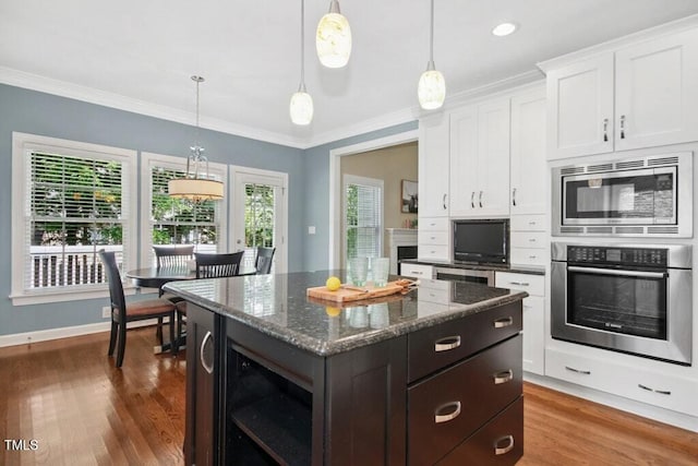 100 Wentbridge Rd, Cary, NC 27519 - kitchen featuring stainless steel appliances, dark wood-type flooring, white cabinetry, a kitchen island, and crown molding
