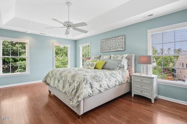100 Wentbridge Rd, Cary, NC 27519 - bedroom featuring baseboards, wood finished floors, a tray ceiling, and ceiling fan