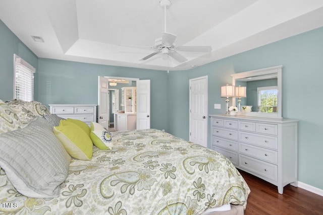 100 Wentbridge Rd, Cary, NC 27519 - bedroom featuring dark wood finished floors, a raised ceiling, baseboards, a ceiling fan, and ensuite bathroom