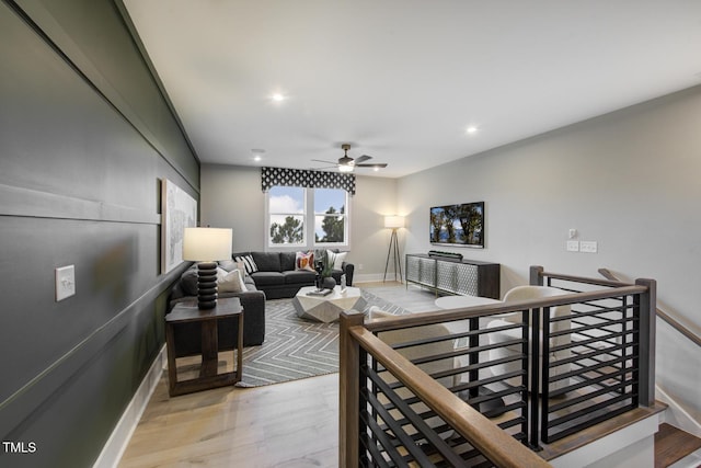 living area featuring baseboards, a ceiling fan, recessed lighting, and light wood-type flooring