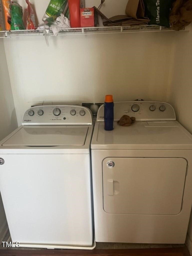 clothes washing area featuring washer and dryer and wood finished floors