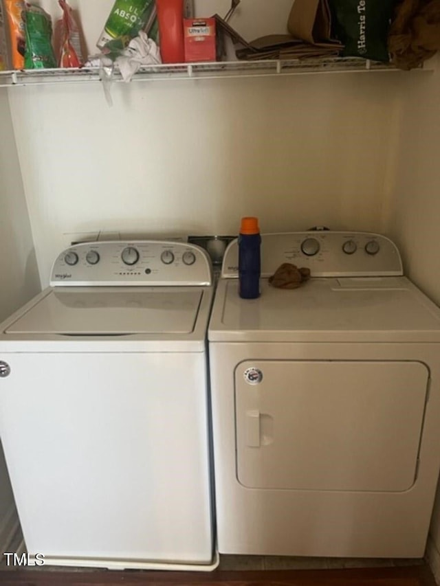 clothes washing area featuring washer and dryer and wood finished floors