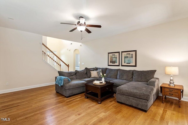 68 Tanners Way, Clayton, NC 27527 - living area featuring a ceiling fan, arched walkways, light wood finished floors, stairway, and baseboards