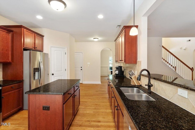 68 Tanners Way, Clayton, NC 27527 - kitchen with a sink, arched walkways, light wood-style flooring, appliances with stainless steel finishes, and dark stone countertops
