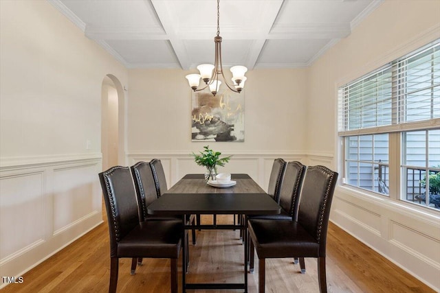 68 Tanners Way, Clayton, NC 27527 - dining space featuring a chandelier, arched walkways, a decorative wall, wood finished floors, and coffered ceiling