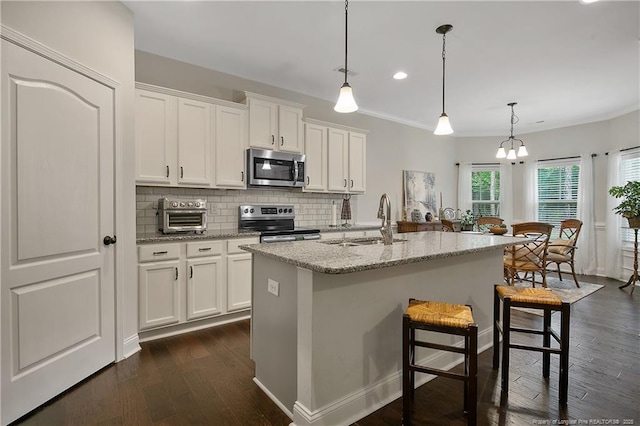 kitchen featuring stainless steel appliances, a sink, dark wood-type flooring, white cabinets, and recessed lighting