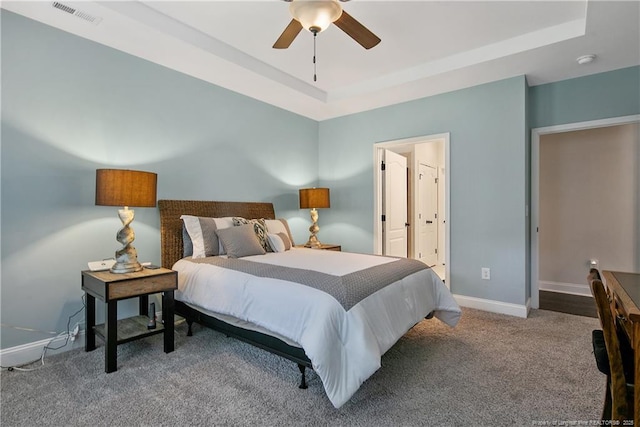 bedroom with a tray ceiling, carpet floors, baseboards, and ceiling fan