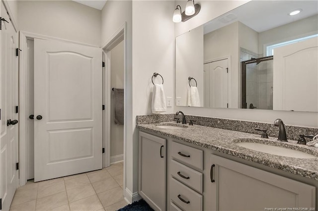 bathroom featuring a stall shower, tile patterned flooring, and double vanity