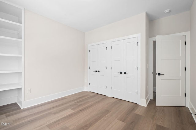 703 E Markham Ave, Durham, NC 27701 - unfurnished bedroom featuring wood finished floors and two closets