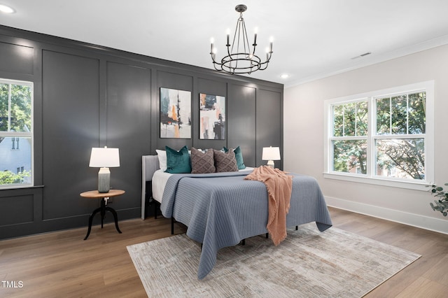 703 E Markham Ave, Durham, NC 27701 - bedroom with crown molding, a chandelier, light wood-style flooring, recessed lighting, and a decorative wall