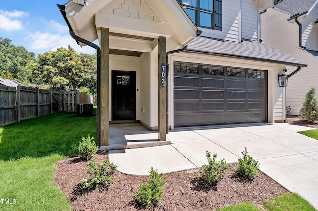 703 E Markham Ave, Durham, NC 27701 - view of exterior entry with driveway, an attached garage, and a shingled roof