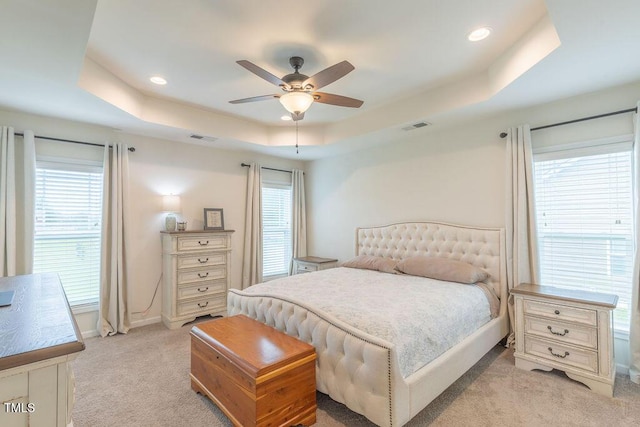 bedroom featuring a raised ceiling, light carpet, multiple windows, baseboards, and recessed lighting