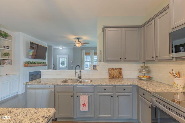 kitchen with gray cabinets, a sink, appliances with stainless steel finishes, and backsplash