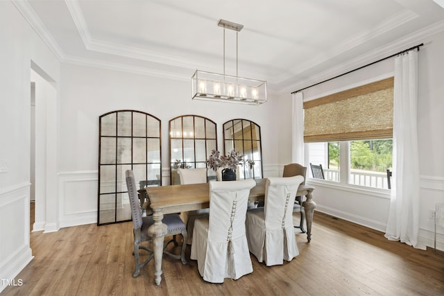 1928 Vandiver Way, Apex, NC 27523 - dining area featuring a chandelier, wood finished floors, crown molding, wainscoting, and a decorative wall
