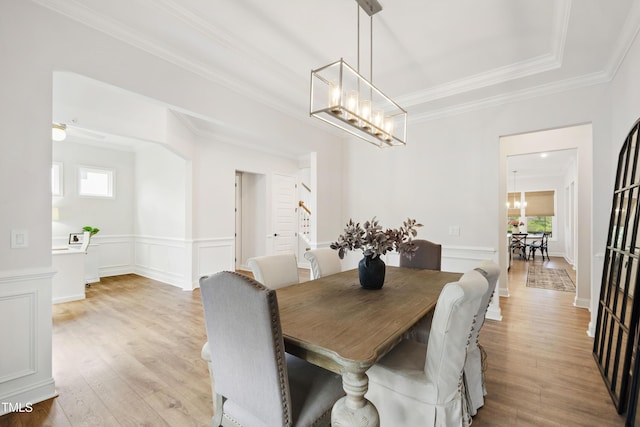 1928 Vandiver Way, Apex, NC 27523 - dining room with a chandelier, light wood-type flooring, crown molding, a wainscoted wall, and a decorative wall