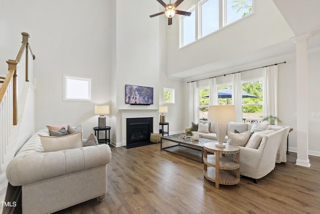 1928 Vandiver Way, Apex, NC 27523 - living room with a towering ceiling, healthy amount of natural light, a ceiling fan, wood finished floors, and a fireplace with flush hearth