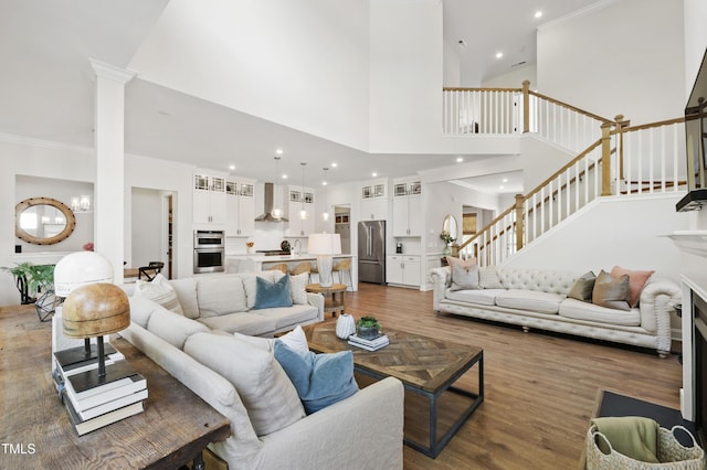 1928 Vandiver Way, Apex, NC 27523 - living room with stairs, dark wood finished floors, a towering ceiling, crown molding, and a chandelier