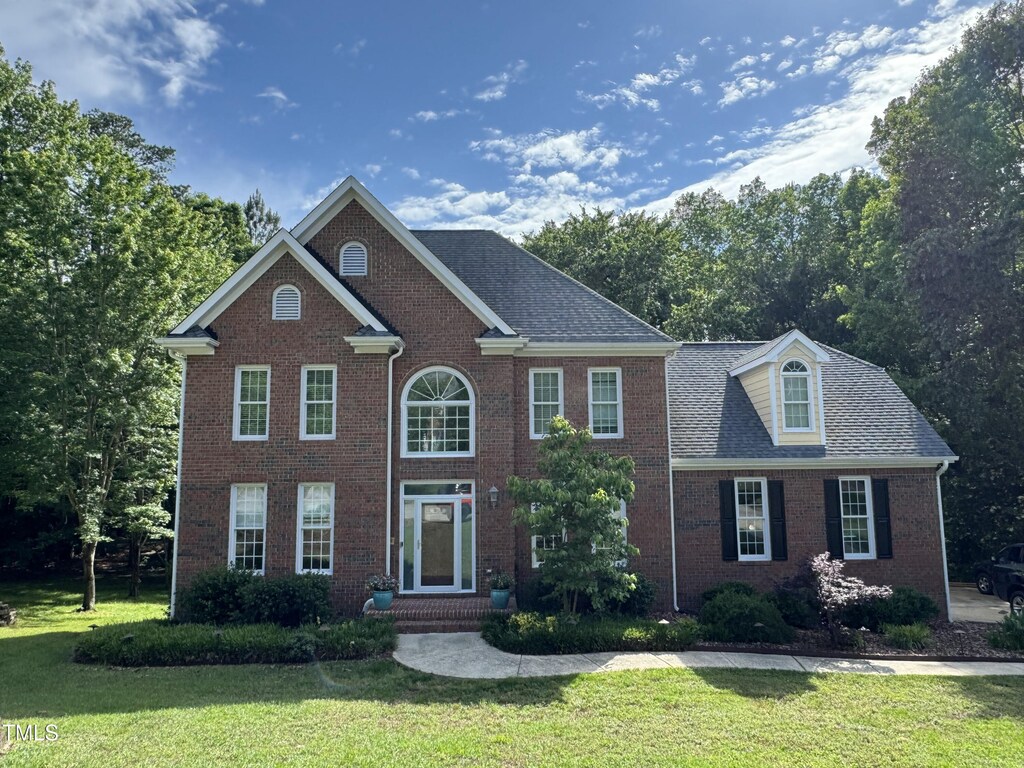 view of front of property with a front yard and brick siding