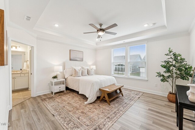 1625 Plover Cir, Fuquay Varina, NC 27526 - bedroom featuring a tray ceiling, light wood finished floors, ensuite bath, crown molding, and recessed lighting