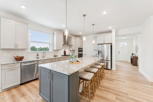 1625 Plover Cir, Fuquay Varina, NC 27526 - kitchen featuring stainless steel appliances, wall chimney range hood, healthy amount of natural light, decorative backsplash, and recessed lighting